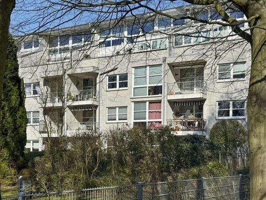 Rückansicht des Mehrfamilienhauses mit Gartenblick