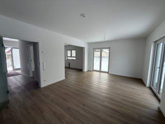 Wohnzimmer mit Zugang  zur offen gestalteten Küche