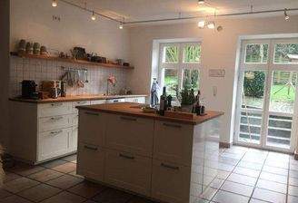 Küche mit Insel und Ausgang zum Garten