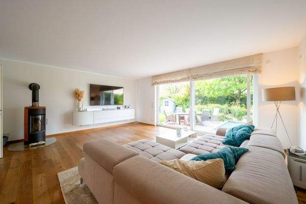 Helles Wohnzimmer mit direktem Zugang zum Garten, gemütlicher Holzofen