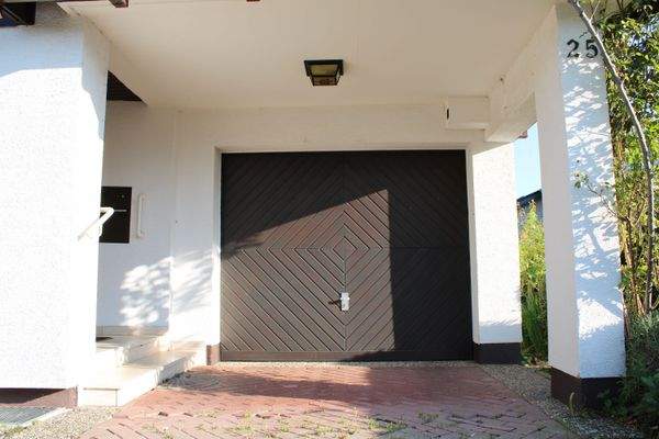 Garage mit elektrischem Tor und überdachtem Zugang