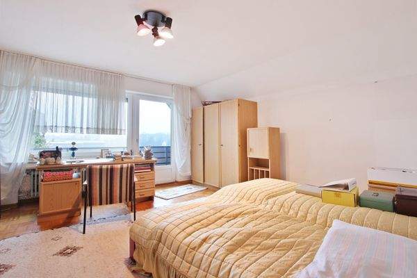 Schlafzimmer mit Balkon im Obergeschoss