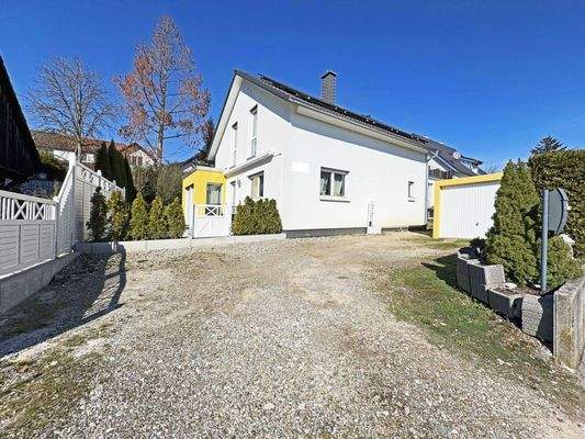 Außenansicht: Hausansicht mit Zufahrt zur Garage und separatem Stellplatz