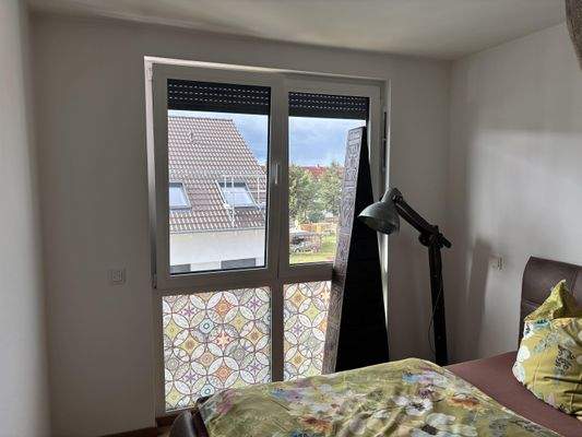 Schlafzimmer mit bodentiefem Fenster