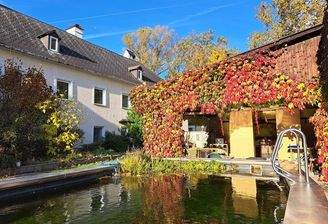 Ansicht Gebäude mit allgemeinem Poll im Vordergrund. Dazwischen private überdachte Terrasse.