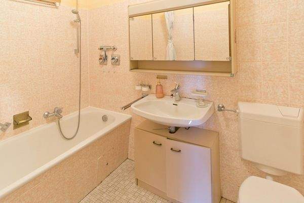 Badezimmer mit Badewanne, WC und Waschmaschinenanschluss