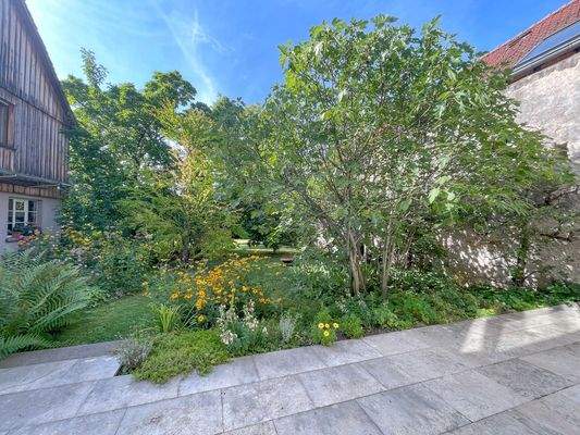 ...und die große Terrasse lädt in den wunderschönen Garten ein