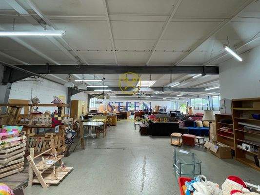 Große Halle mit Stahlträgern und Betonboden