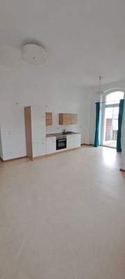 Wohnraum mit offener Küche u. Zugang Balkon