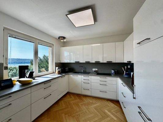 Einbauküche mit Seesicht und angrenzendem Hauswirtschaftsraum