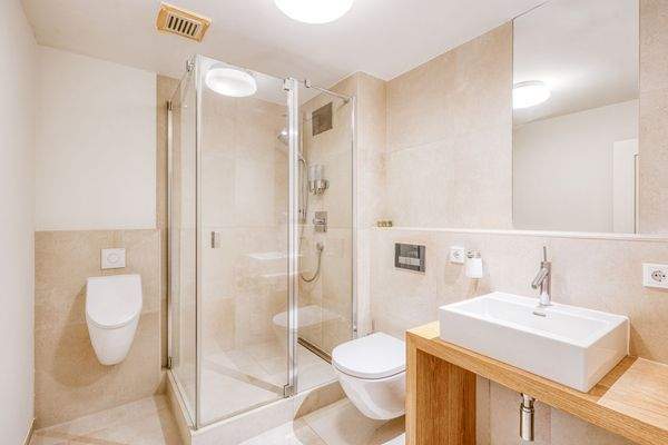 Modernes Duschbad mit Naturstein und bodengleicher Dusche