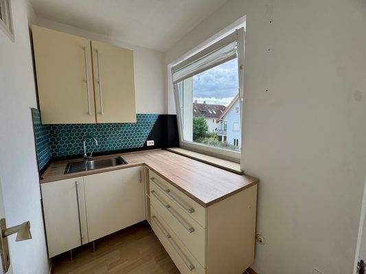 Küche mit Einbauküche und Fenster