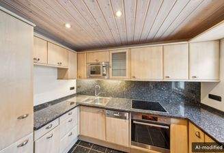 Einbauküche in warmen Holztönen mit dunkler Arbeitsplatte und viel Stauraum