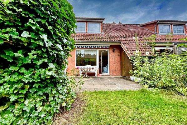 Sonnige Terrasse mit kleinem Garten