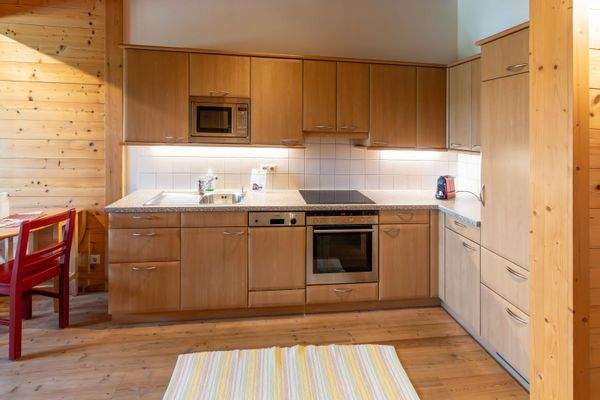 Voll ausgestattete Küchenzeile mit Herd, Backofen, Mikrowelle und viel Stauraum.