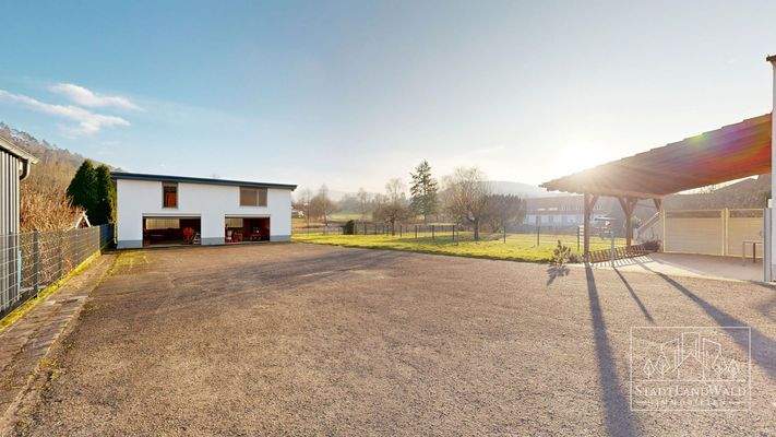 Hof mit Blick zur Doppelgarage, Garten und überdachter Terrasse