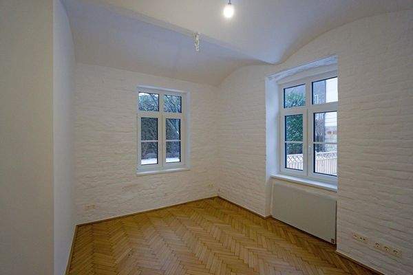 Wohnzimmer mit Fischgrätparkett und Elektro-Radiator