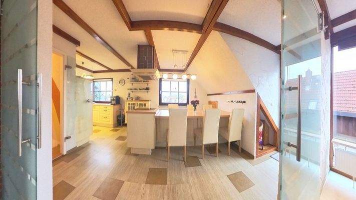 Blick in die Küche mit Kochinsel und Essbereich