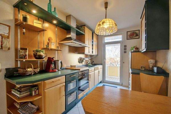 Küche mit Einbauküche und Zugang zum Balkon