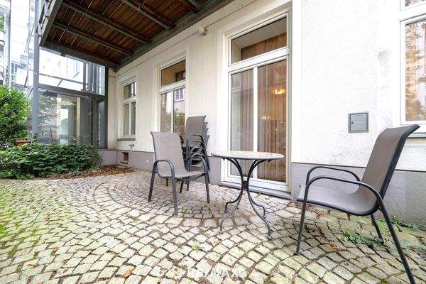 Gepflasterte Terrasse/Garten neben Wohnküche