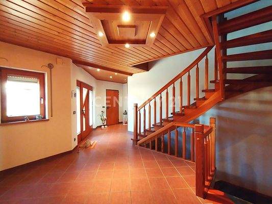 Der großzügige helle Eingangsbereich mit Holztreppe