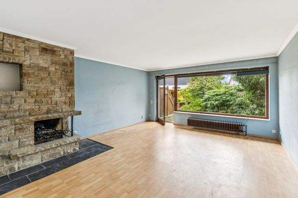 Wohnzimmer mit Kamin und großem Westfenster