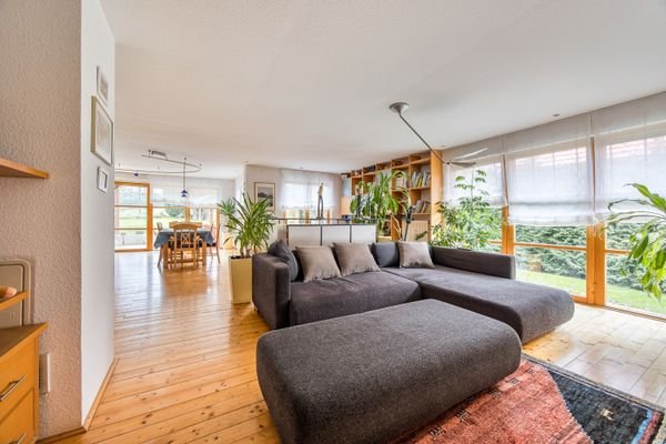 Gemütlicher Wohnbereich mit Landhausdielen und Blick in den gepflegten Garten