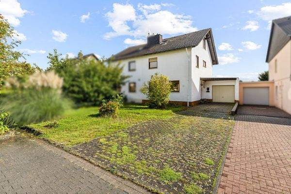  Haus mit Gartenfläche davor, Außenstellplätzen und Zufahrt zur Garage 