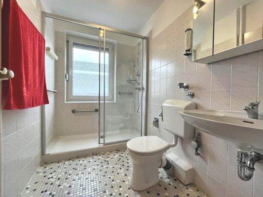 Die fast bodengleiche Dusche wird mit einer Schiebetür geschlossen