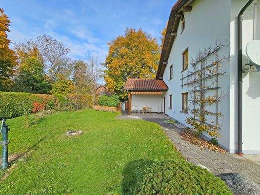 Blick auf seitlichen Garten mit Terrasse an Hauswestseite