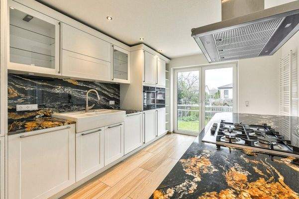 Offene Einbauküche im modernen Landhausstil mit Naturstein-Arbeitsplatten