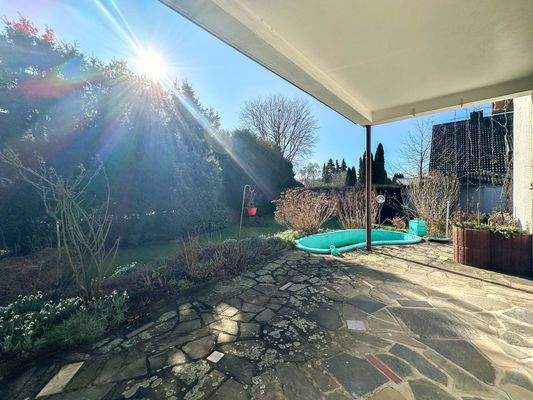 Überdachte Terrasse mit mediterranem Natursteinbelag