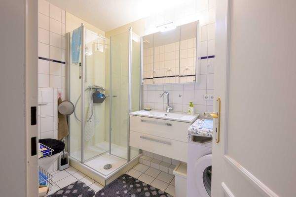 Badezimmer mit WC, Dusche, Waschbecken und Waschmaschine.jpg