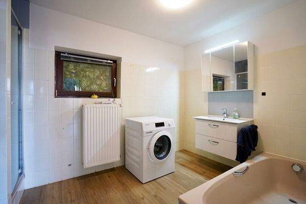 Badezimmer mit Badewanne und Waschmaschinenanschluss der Einliegerwohnung