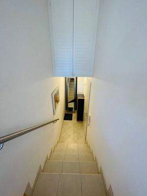 Flur mit Garderobe und Treppenaufgang. Zusätzlicher Stauraum oben.