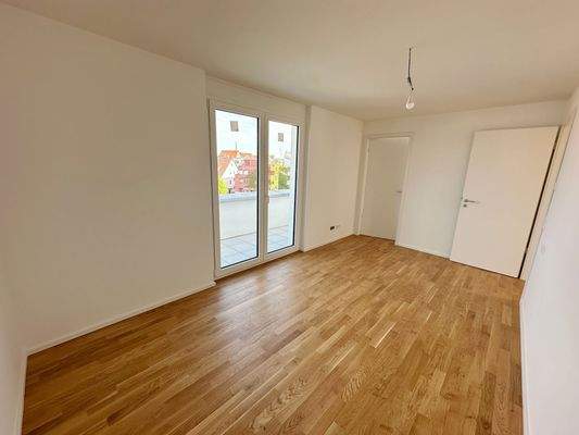 Schlafzimmer mit Zugang zum Balkon und Ankleide