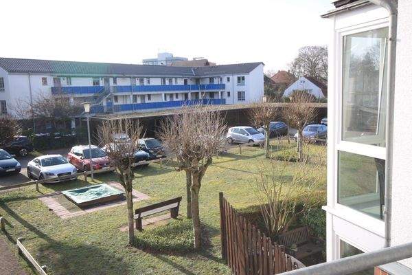 Blick vom Balkon in den gepflegten Innenhof der Wohnanlage