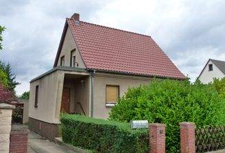 Vorderansicht mit Giebelbereich, Hauseingang und darüberliegender Terrasse