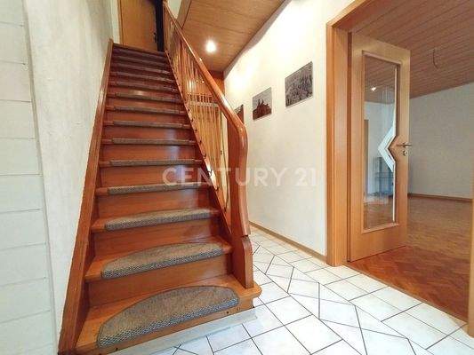 Der Flur mit wunderschöner Holztreppe und Zugang zum Wohnber