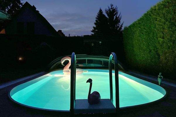 Swimmingpool mit fahrbarem Dach bei Nacht