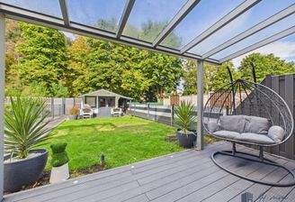 Viel Platz für die Familie: Die überdachte Lounge-Ecke und der pflegeleichte Garten mit Gartenhaus