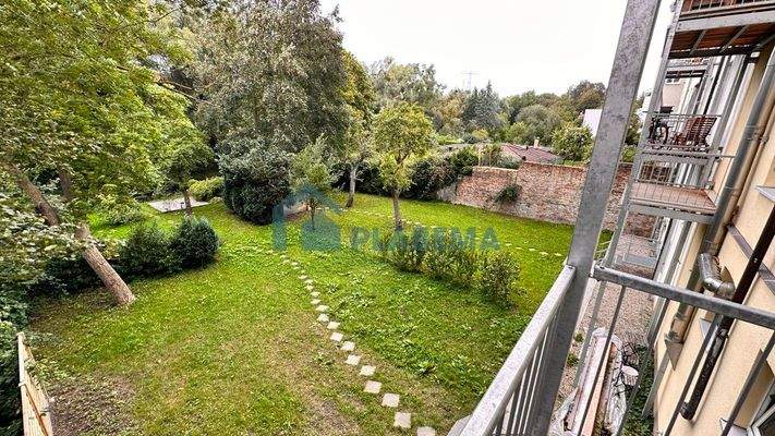 Blick vom Balkon in das grüne Grundstück