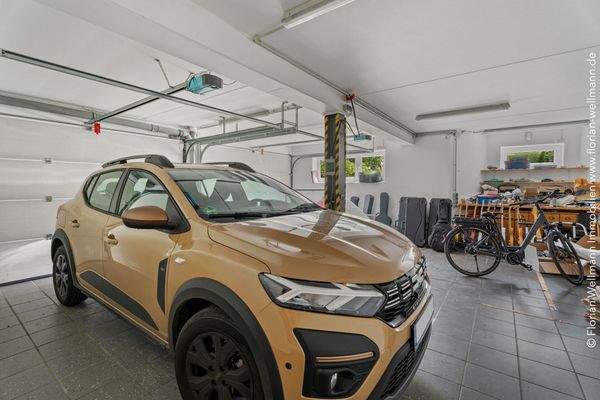 70,61 m² große, geflieste Garage mit zwei elektrischen Zufahrtstoren und direktem Zugang ins Haus