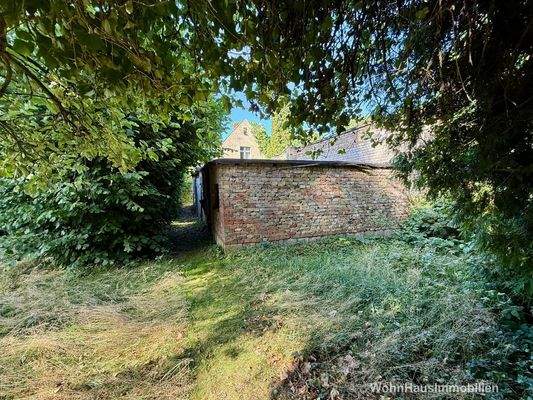 Blick vom Garten auf Haus und Nebengebäude