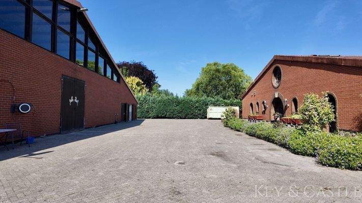 Ansicht auf das Heulager (re.) und das Hauptstallgebäude mit Halle (li.)