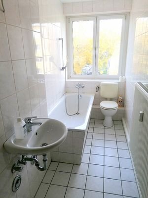 gefliestes Bad mit Wanne und Fenster