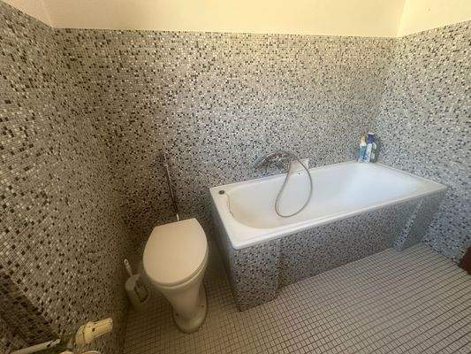 Wannenbad mit Mosaikfliesen