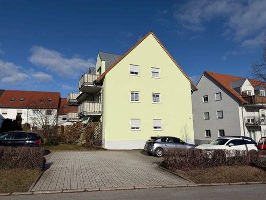 Hausansicht mit Parkplätzen