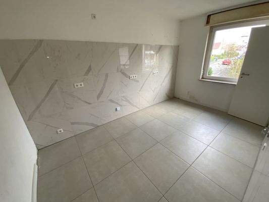 Küche mit großformatigen Wand- und Bodenfliesen