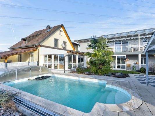 Einladende Poolanlage, eingerahmt von Altbau (gelb) und Neubau (grau)